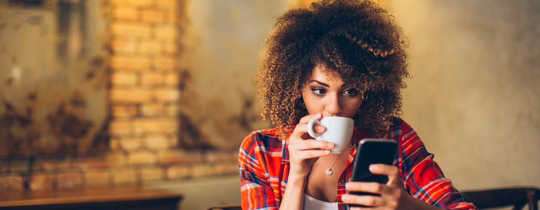 Woman drinking coffee on phone